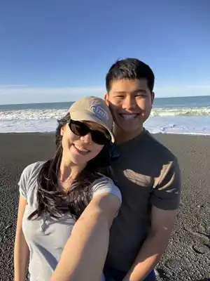 Gabriel and Estella smiling by the beach