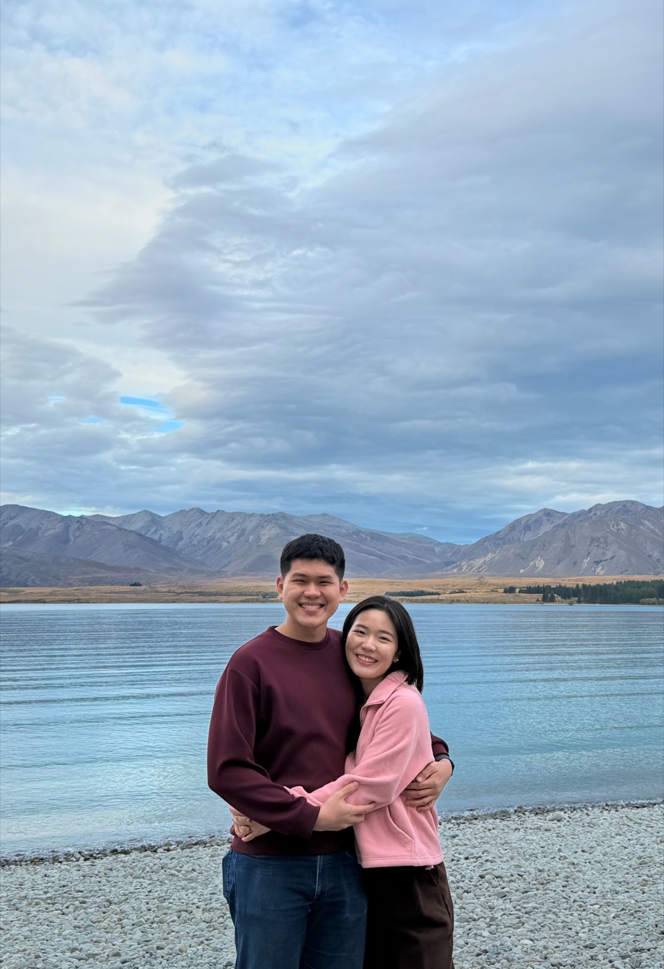 Gabriel and Estella hugging by a New Zealand lake