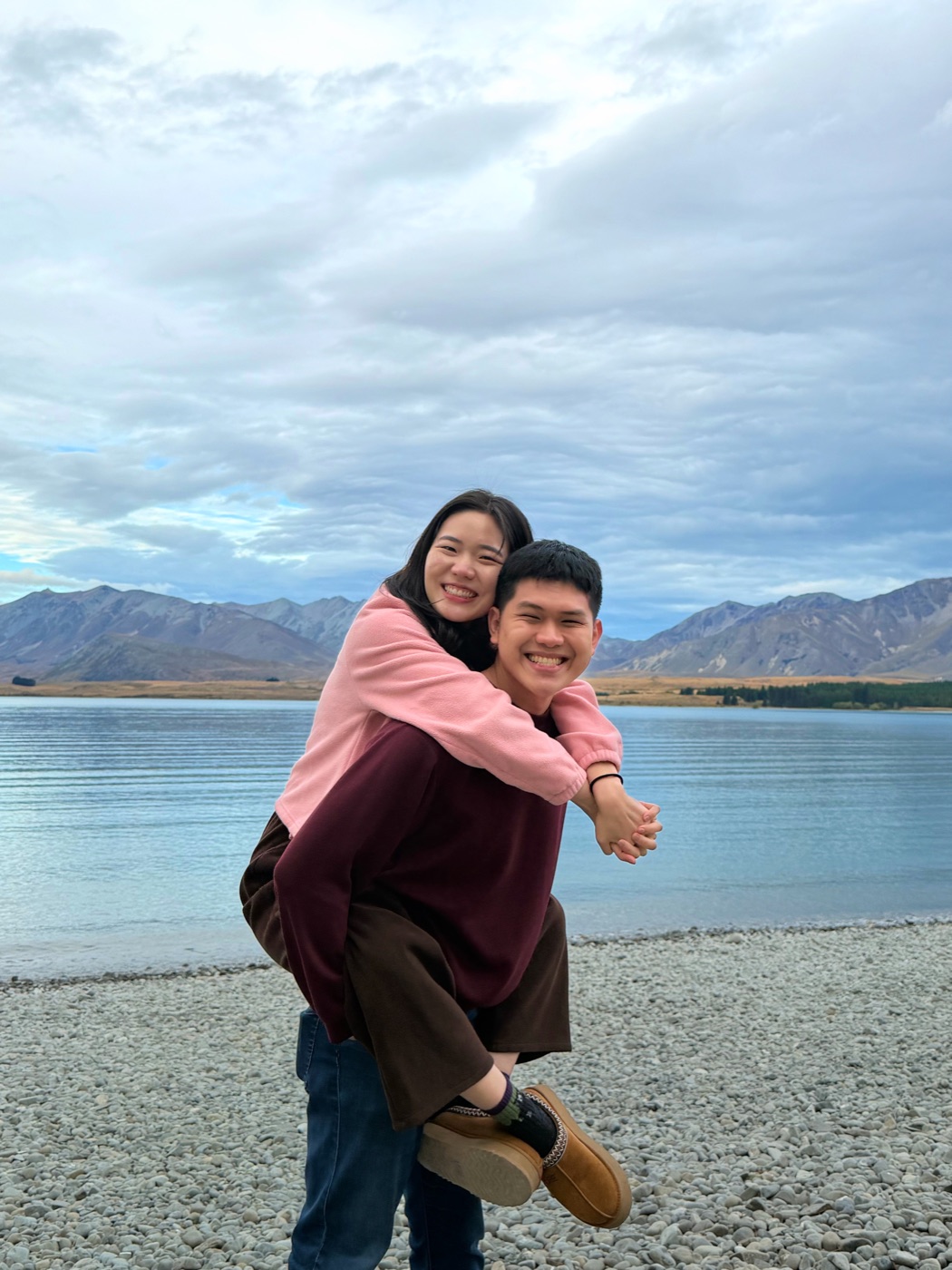 Gabriel carrying Estella by a lake in New Zealand