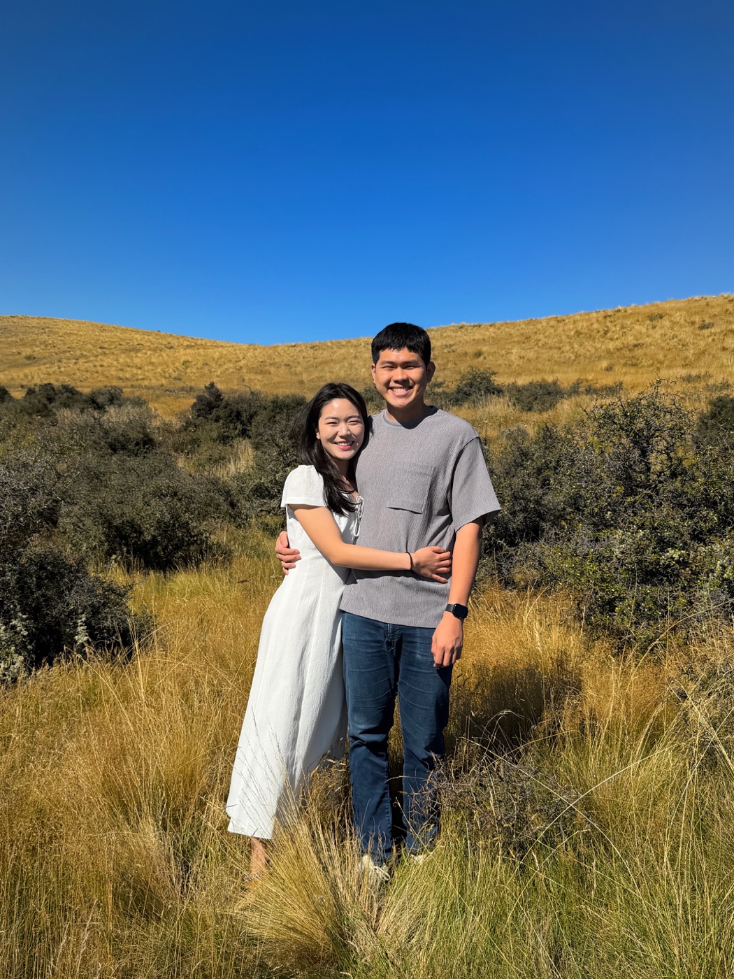 Gabriel and Estella standing in golden grass