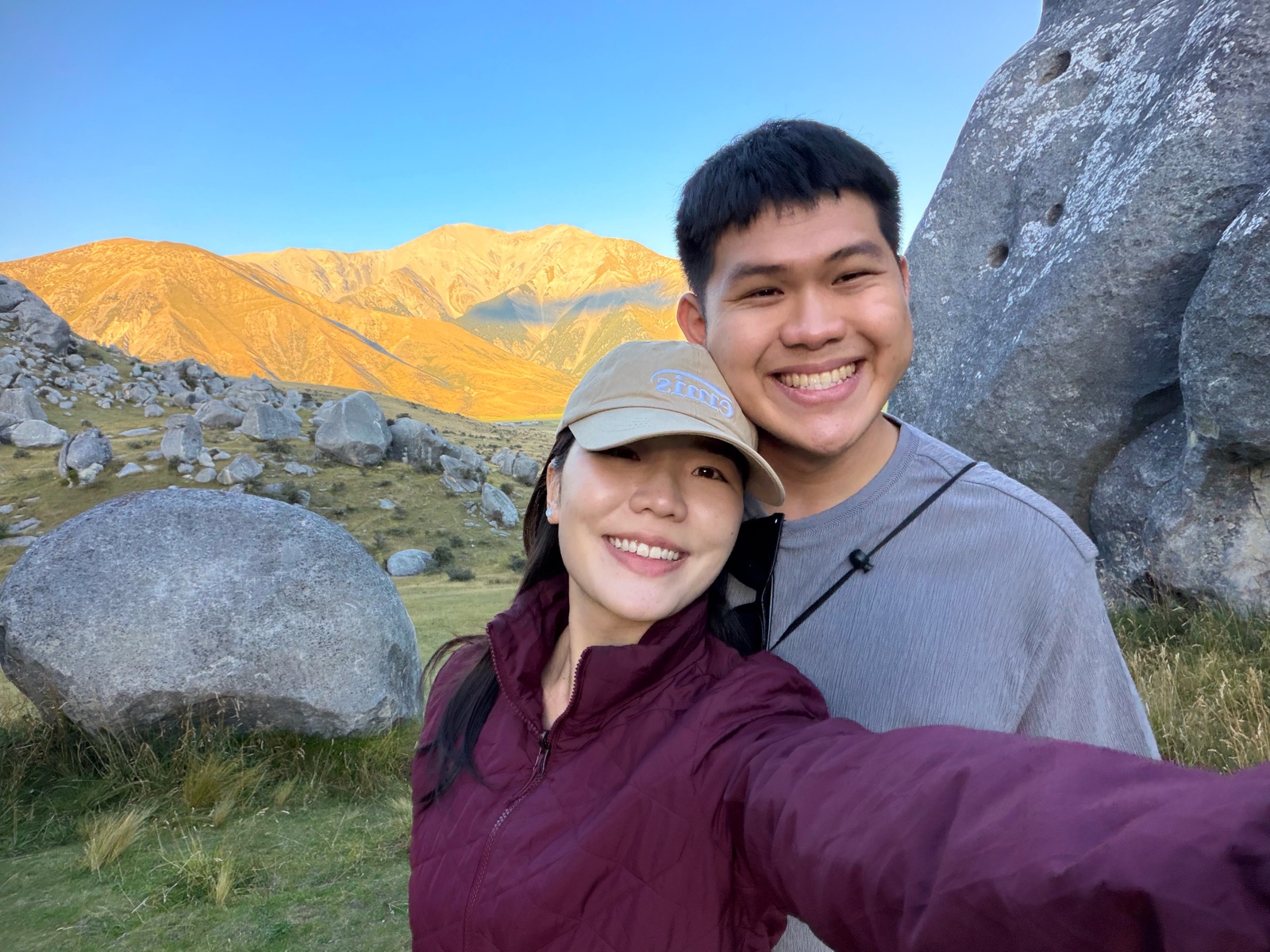 Gabriel and Estella at Castle Hill with sunlit hills behind them